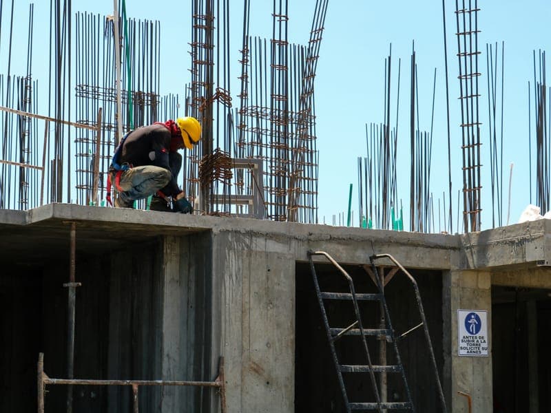 Obrero atando hierros sobre una losa en una obra en construcción