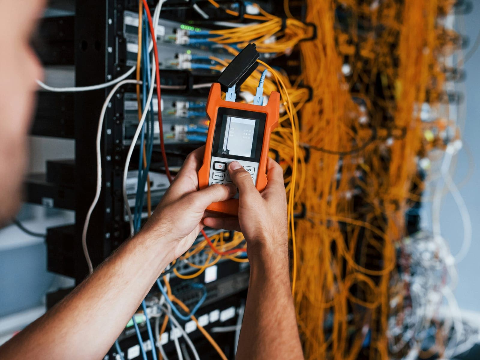Técnico midiendo con un instrumento sobre un rack de cableado